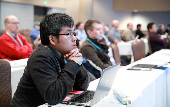 A man listening to a conference presentation