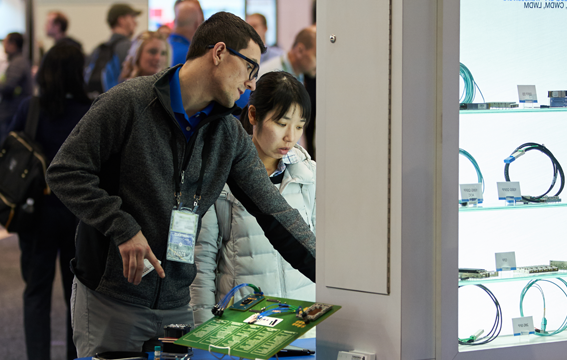 Two attendees view a display at DesignCon