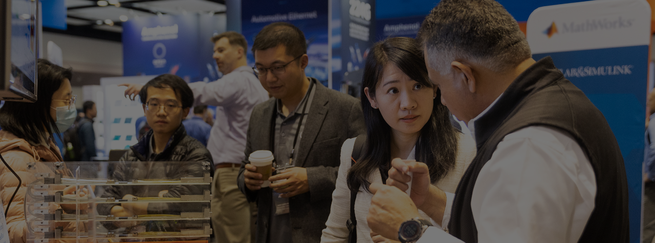 Exhibitor explains a circuit board to an attendee.